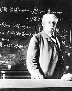 Hermann Helmholtz in späteren Jahren vor Schultafel mit Formeln